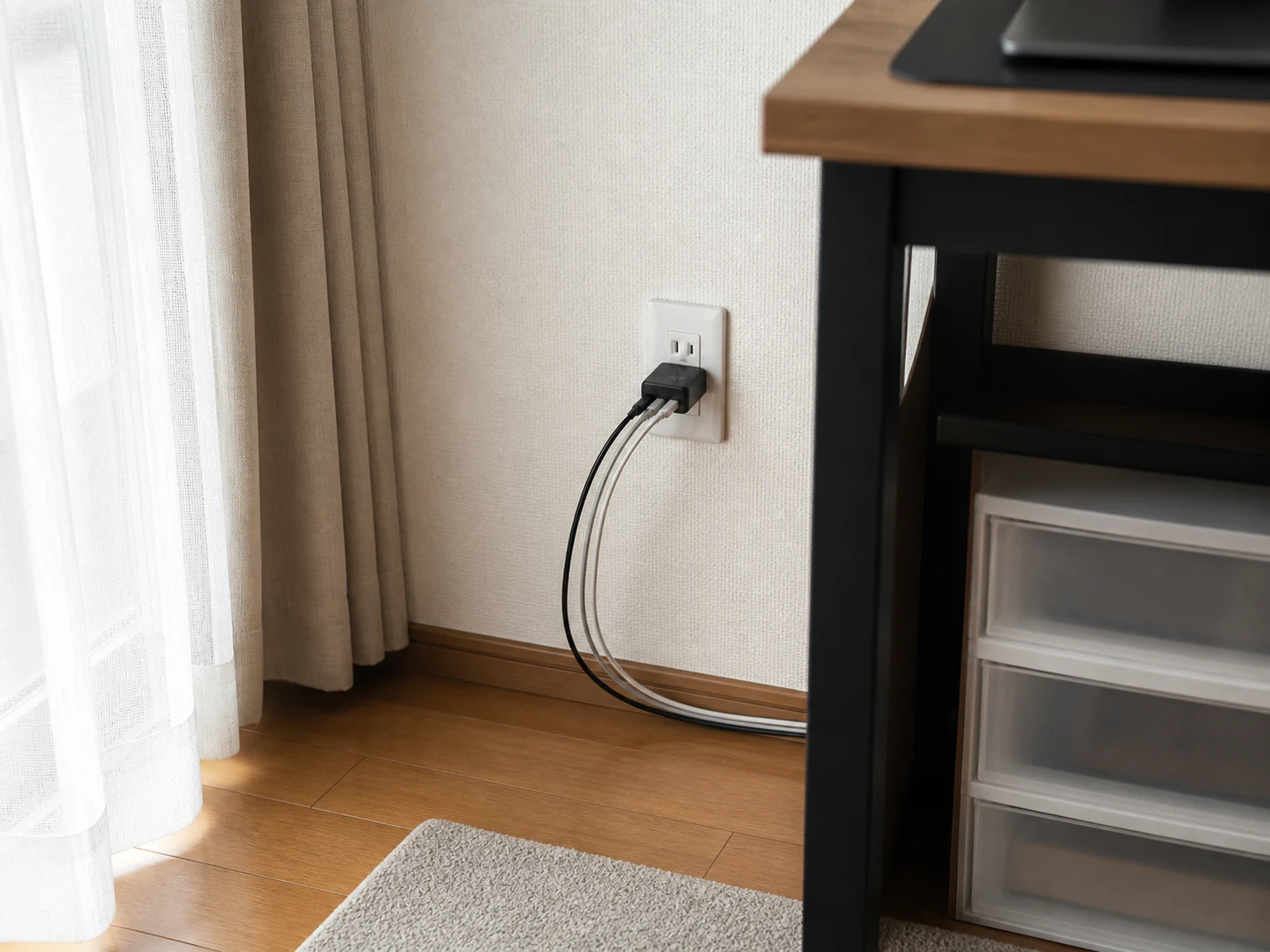 日本の壁コンセントに挿した3ポート充電器から机へケーブルを逃がす配置イメージ