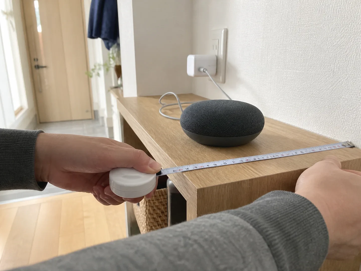 1LDKの棚で小型スマートスピーカーの置き場所を測るイメージ