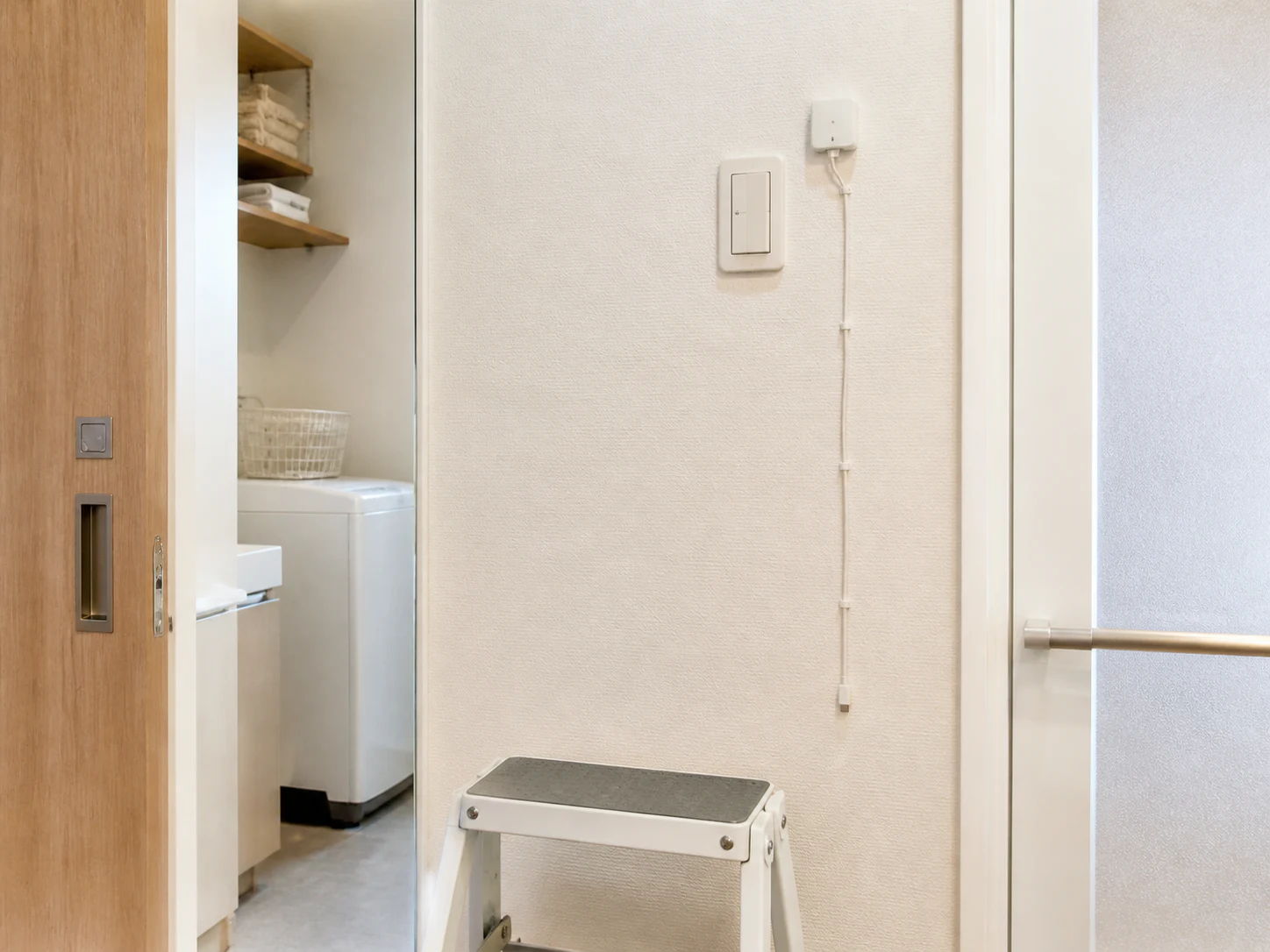 高い壁スイッチに取り付けたボタンプッシャーと充電ケーブルの経路