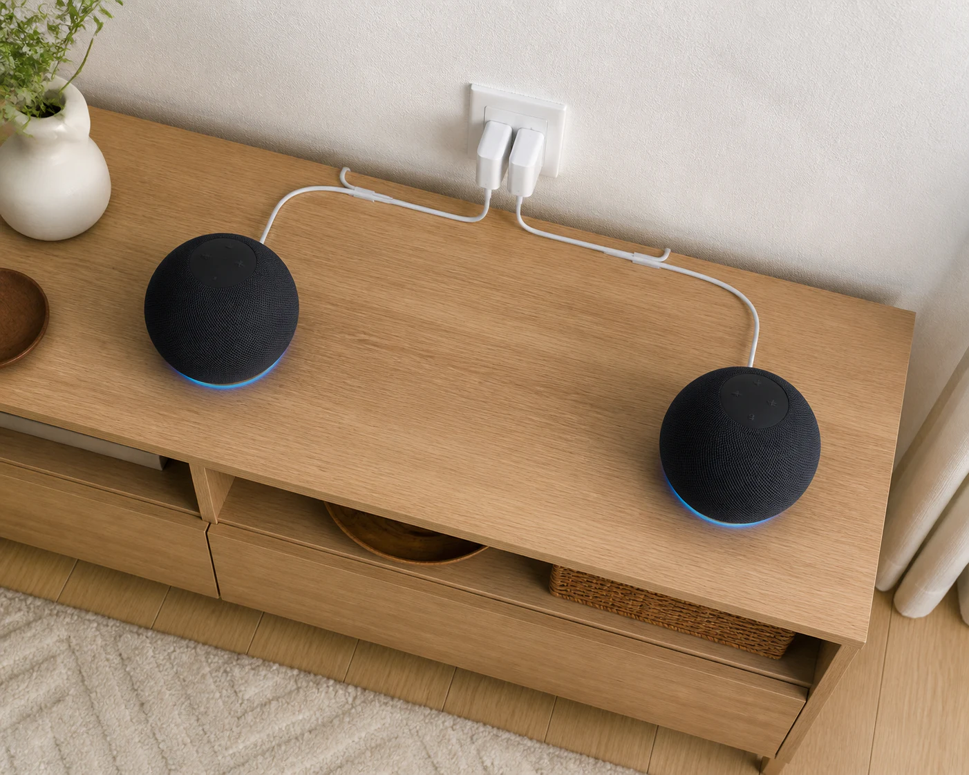 木製コンソールの左右に置いた同じ形のスマートスピーカーと、背面へ沿わせた電源ケーブル